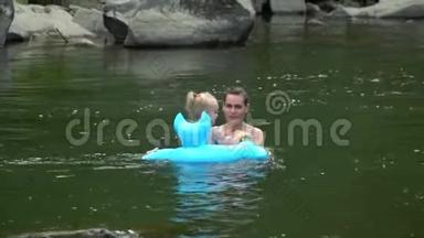 妈妈和女儿在<strong>河里</strong>。 一个年轻漂亮的女人正和她的小女儿一起在山<strong>河里</strong>洗澡。 他们是
