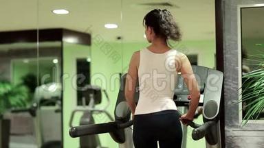 女人在健身房跑步机上行走。 健身房锻炼，跑步机有氧运动