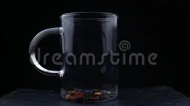 玻璃杯中茶叶中倒入开水的宏观镜头。 冲泡红茶.. 宏观拍摄的过程