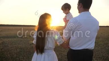 <strong>一家人</strong>在日落时和婴儿玩。 日落时分，爸爸和妈妈和她的<strong>女儿</strong>抱在怀里散步。 父亲