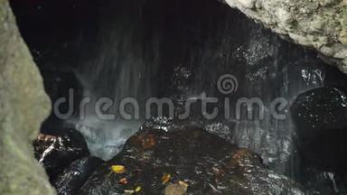 森林岩石后面的洞穴瀑布
