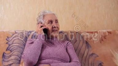 一位坐在沙发上用<strong>手机</strong>说话的老年妇女。 他通过<strong>手机</strong>、智能<strong>手机</strong>进行交流。