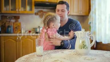 小女孩和他父亲一起喝牛奶。 女儿给父亲喝牛奶。