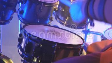 在摇滚音乐会上，用木棍在鼓上演奏的专业鼓手面目全非。 音乐鼓。 关门