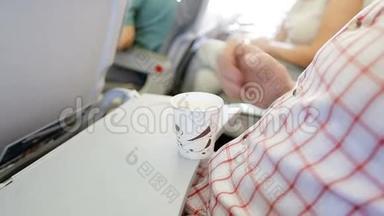人在飞机上玩咖啡杯.. 坐在乘客车厢里的人旅行者。