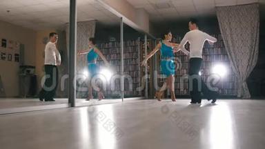 年轻迷人的男人和女人在工作室里穿着服装跳舞和排练拉丁美洲舞蹈