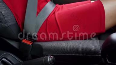 在驾驶前，身着红色礼服的女士在车内系紧安全带