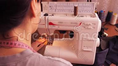 <strong>缝纫机</strong>上的裁缝工作。 女孩坐在桌子旁，在<strong>缝纫机</strong>上涂鸦。