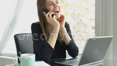 女商人在办公室里打电话，用手提<strong>电脑打字</strong>