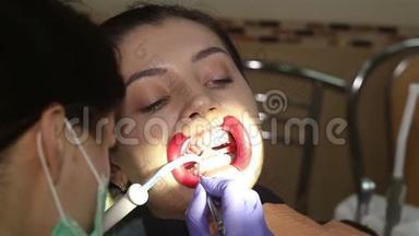 在牙科诊所有<strong>扩张器</strong>的年轻女子。 保护美白凝胶在牙齿上的应用。
