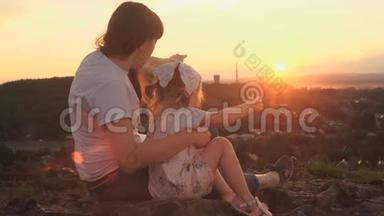 在夏天的傍晚，妈妈和女儿坐在山上打电话