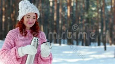 女孩从一个金属热水瓶里倒热饮料，手里的热水瓶紧闭，手把茶倒在杯子里，