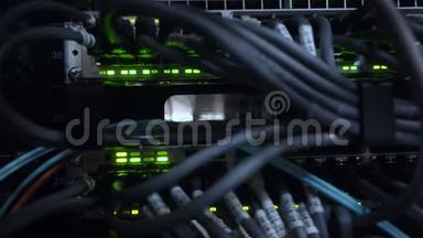以太网网络连接枢纽.. 黑暗服务器机房的闪烁灯光，连接到路由器4K的以太网电缆的特写镜头