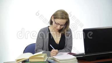 <strong>女老师</strong>在笔记本电脑前检查教室里的作业