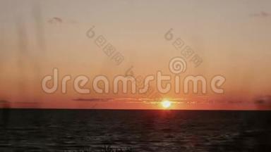 一段时间的视频，小指橙色日落在海边，干草摇曳在前面的景色。