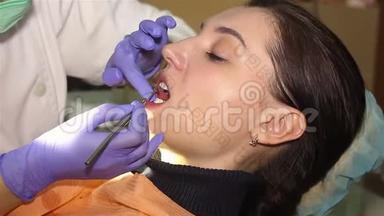 在牙科诊所有扩张器的年轻女子。 保护美白凝胶在牙齿上的应用。