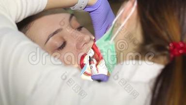 在牙科诊所有<strong>扩张</strong>器的年轻女子。 保护美白凝胶在牙齿上的应用。