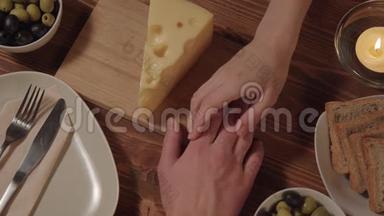 女人牵着桌子上男人的手是奶酪橄榄