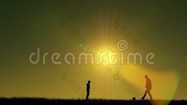 日落时分，父亲和儿子在公园里<strong>踢</strong>足球，在灿烂的阳光下剪影