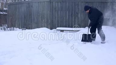 雪夜后工作.. 在一个寒冷的雪天早晨，一个拿着铲子把雪从院子里移走的人