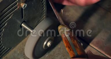 磨刀机上的旧刀磨尖.. 特写