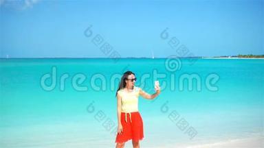 年轻女子在热带海滩度假时使用电话。 使用移动智能手机的游客。