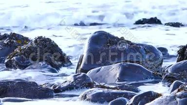 <strong>黑色</strong>圆形石头在塔利斯克湾西海岸的斯凯岛在晚上涨<strong>潮</strong>。 巨大的海浪