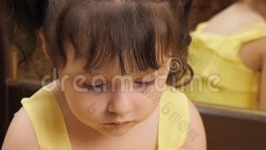 孩子的情绪.. 一个大眼睛的小女孩在哭。 一个穿着黄色裙子的孩子在镜子旁