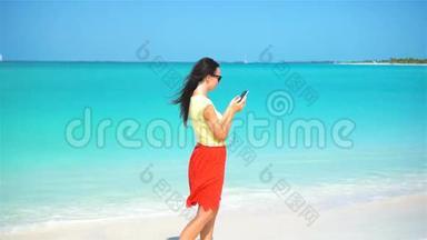 年轻女子在热带海滩度假<strong>时使用</strong>电话。 <strong>使用</strong>移动智能手机的游客。