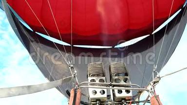 大型燃气燃烧器用热空气充气气球上升到地面以上。 空中飞行的巨大气球，游客