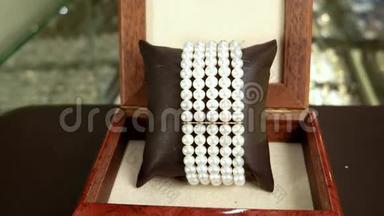 珠宝首饰，项链珍珠产品在精英珠宝店珍珠手镯在棕色木制棺材，经典珠宝为
