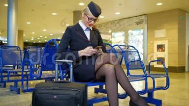 在机场，空姐拿着行李，拿着智能手机。