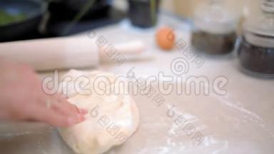面包师正在用厨房里的面粉捏桌子上的面团