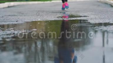 用运动鞋将跑步者腿部的慢动作镜头闭合. 女运动员在公园户外慢跑，<strong>踏入</strong>