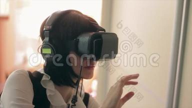 年轻的黑发女人玩游戏使用VR头盔智能手机。 增强现实设备允许深入到虚拟