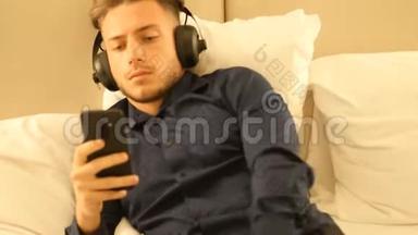 躺在床上用耳机听音乐的年轻人