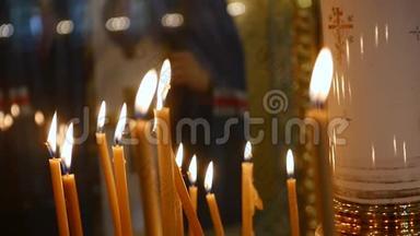 在教堂的视野从燃烧蜡烛的基督的脸在图标。 利克圣焰蜡烛。 许多教堂蜡烛