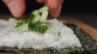 寿司厨师把黄瓜片放在<strong>白米饭</strong>上