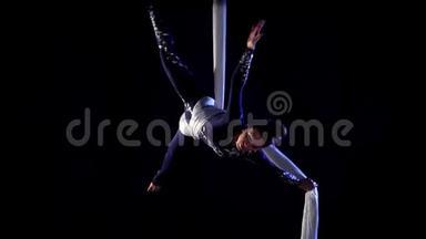 空中丝绸上的女舞者。 动作缓慢。 空中体操。 杂技表演。