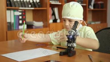 一个在实验室里拿显微镜的小男孩