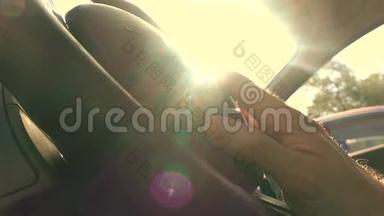 快乐的司机用手指在方向盘上敲打着炽热的太阳，温暖的颜色。 4K视频