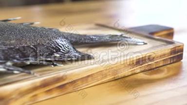 在木板上用蔬菜装饰烤鱼。 用新鲜蔬菜在木制背景上烤鱼。 海鲜