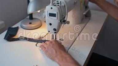 裁缝手在缝纫机上工作，在时装设计工作室制造接缝