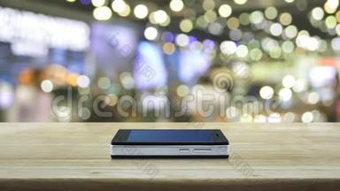 现代智能手机屏幕上的银行平面图标在木制桌子上，在购物中心模糊的光影上，商业银行o