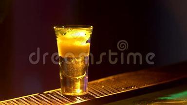 酒保正在制作鸡尾酒，并添加绿色，三种不同的液体，在酒吧柜台的边缘，拍摄，关闭，背部