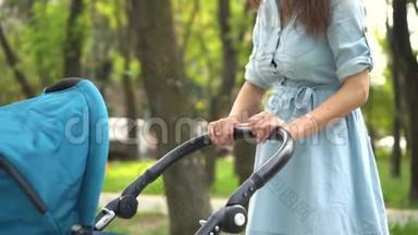 妈妈带着婴儿车在<strong>公园</strong>里<strong>散步</strong>。 夏季自然背景。