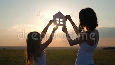剪影<strong>幸福</strong>的母女和梦想的房子。 纸房子作为象征.. 家庭<strong>幸福</strong>的概念..