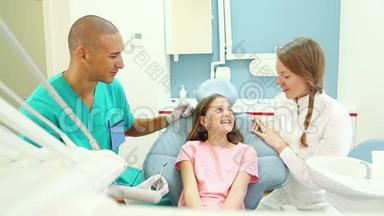 可爱的小女孩与牙医和助手交谈，展示她的疼痛牙齿