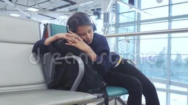 戴着耳机的少女睡<strong>在机场</strong>等待飞机起飞，登机门，生活方式长椅