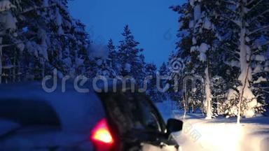 冬季森林的夜间降雪和一辆有<strong>大灯</strong>的<strong>汽车</strong>